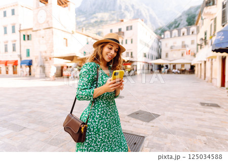 Pretty woman walks the streets with mobile phone. Tourist using mobile app searching way. Pretty woman walks the streets with mobile phone. Tourist using mobile app searching way. 125034588