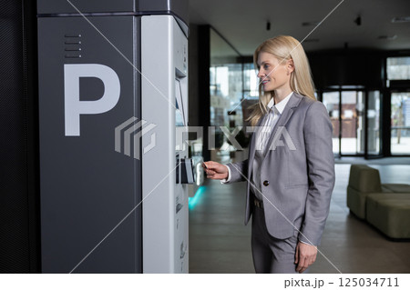Woman inserting card into machine for parking ticket payment with wireless system Woman inserting card into machine for parking ticket payment with wireless system 125034711