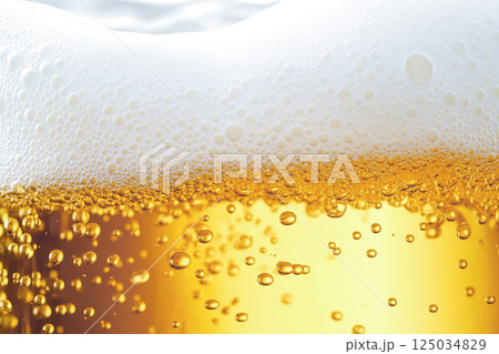 ビールの泡と黄金の炭酸がはじけるクローズアップ。夏の飲み物イメージ 125034829