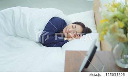 ベッドで寝ている女性 125035206