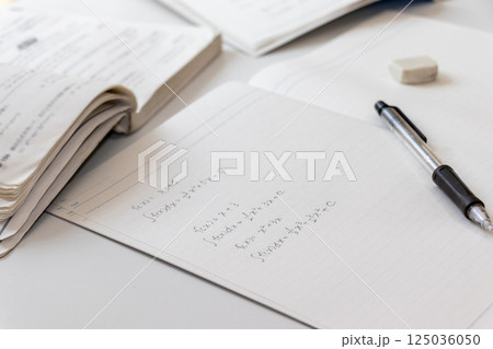 机の上に広げられたノートと筆記用具 125036050