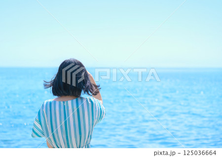爽やかな海を眺めるワンピースの女性 125036664