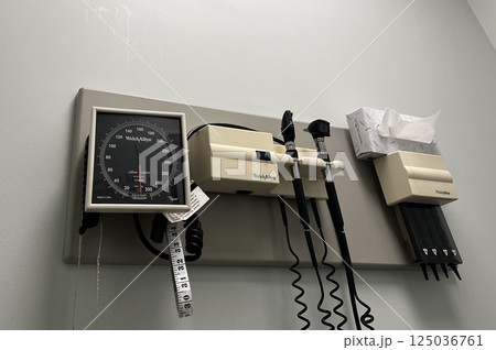病院の診察室の壁に設置された血圧測定器などの医療用具 125036761