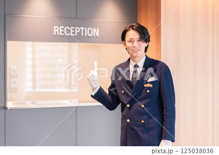 笑顔で接客をするホテルマンの男性 125038036
