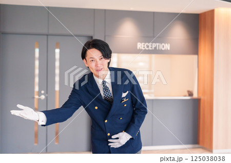 笑顔で接客をするホテルマンの男性 125038038