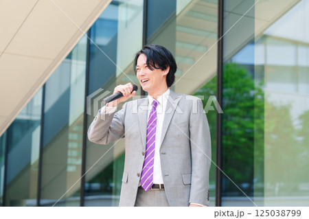 マイクを使って街なかで演説をするスーツを着た男性 マイクを使って街なかで演説をするスーツを着た男性 125038799