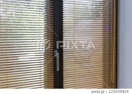 Close-Up of Wooden Blinds on Glass Door 125038924