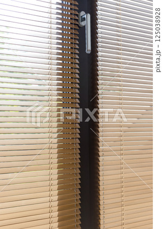 Sunlight Through Partially Opened Window Blinds with Handle 125038928