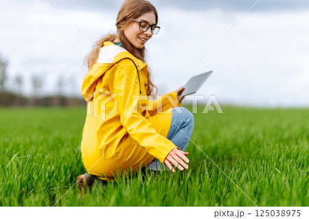 Innovative smart farm system technology, agricultural management. Farmer with tablet in green field 125038975