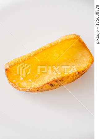 Single crispy potato dipper isolated against bright white background, fried to perfection 125039379