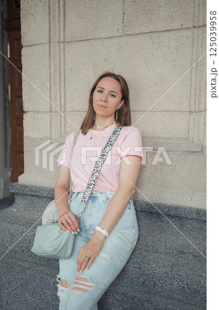 Casual Young Woman Leaning Against Stone Wall Casual Young Woman Leaning Against Stone Wall 125039958