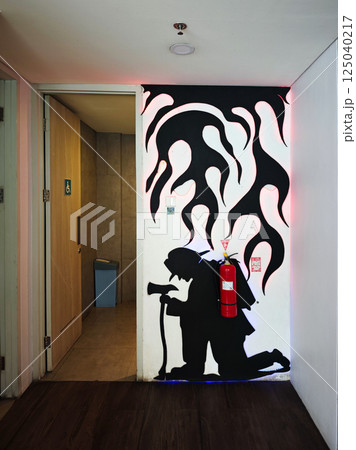 Silhouette Mural of Firefighter in Front of Disabled Accessible Public Toilet with Red Fire Extinguisher and Unique Artistic Design Silhouette Mural of Firefighter in Front of Disabled Accessible Public Toilet with Red Fire Extinguisher and Unique Artistic Design 125040217