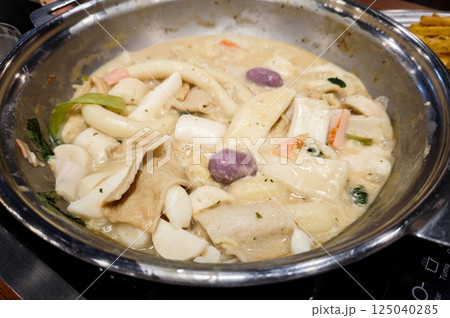 Delicious Korean Tteokbokki and Fish Cakes in Creamy Carbonara Sauce Served in a Stainless Steel Pan on a Wooden Table at a Cozy Restaurant Delicious Korean Tteokbokki and Fish Cakes in Creamy Carbonara Sauce Served in a Stainless Steel Pan on a Wooden Table at a Cozy Restaurant 125040285