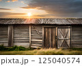 Golden Sunset Over Rustic Wooden Barn Amidst Tranquil Countryside 125040574