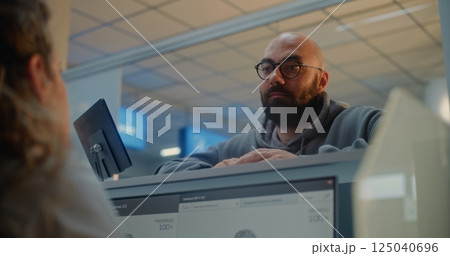 Female Airline Worker Checking Personal ID Data on Computer, Giving Passport and Airplane Ticket to Man Female Airline Worker Checking Personal ID Data on Computer, Giving Passport and Airplane Ticket to Man 125040696