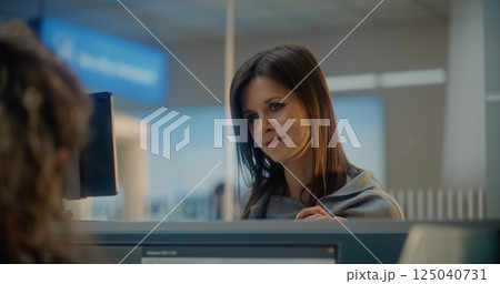 Check-in Counter: Close Up of Woman Talking to Airline Worker, Waiting for Passport Check 125040731