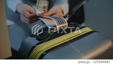 Close Up of Female Airline Worker Putting Luggage Tag Sticker on Suitcase Close Up of Female Airline Worker Putting Luggage Tag Sticker on Suitcase 125040862