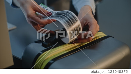 Close Up of Female Airline Worker Putting Luggage Tag Sticker on Suitcase 125040876