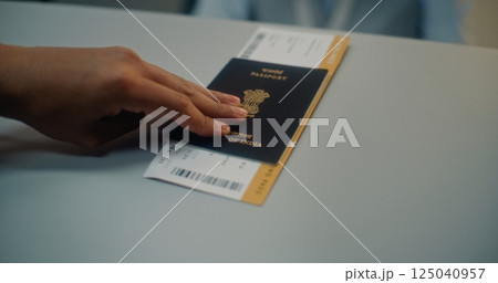 Airport Terminal: Close Up of Tourist Putting Indian Passport with Flight Ticket on Counter Airport Terminal: Close Up of Tourist Putting Indian Passport with Flight Ticket on Counter 125040957