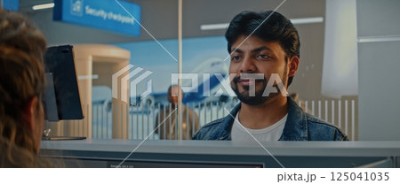 Airport Check-in Counter: Indian Man Giving Documents, Verifying by Facial Recognition Scanning Airport Check-in Counter: Indian Man Giving Documents, Verifying by Facial Recognition Scanning 125041035