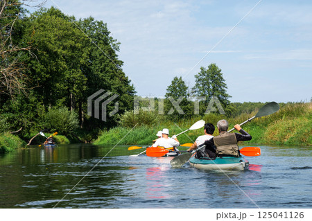 Group kayak trip for seigneur and senora. An elderly couple And adult rowing boat on the river, a water hike, a summer adventure. Age-related sports, mental youth and health, tourism, active old age Group kayak trip for seigneur and senora. An elderly couple And adult rowing boat on the river, a water hike, a summer adventure. Age-related sports, mental youth and health, tourism, active old age 125041126