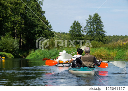 Group kayak trip for seigneur and senora. An elderly couple And adult rowing boat on the river, a water hike, a summer adventure. Age-related sports, mental youth and health, tourism, active old age 125041127