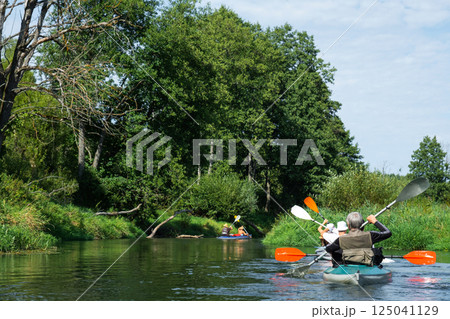 Group kayak trip for seigneur and senora. An elderly couple And adult rowing boat on the river, a water hike, a summer adventure. Age-related sports, mental youth and health, tourism, active old age 125041129