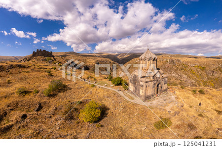 Aerial drone view of famous Vahramashen Church of the 11th century, located near destroyed Amberd fortress in sunny summer day. Cliff with Arkashian River deep in canyon. Aragatsotn region, Armenia 125041231