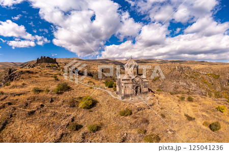 Aerial drone view of famous Vahramashen Church of the 11th century, located near destroyed Amberd fortress in sunny summer day. Cliff with Arkashian River deep in canyon. Aragatsotn region, Armenia 125041236