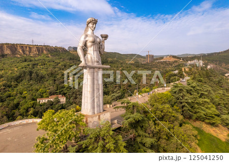Aerial panoramic view of statue of Mother of Georgia Kartlis Deda by georgian sculptor Elguja Amashukeli from drone. Monument overlooking Tbilisi City from Sololaki Hill. Erected in 1958. Europe. 125041250