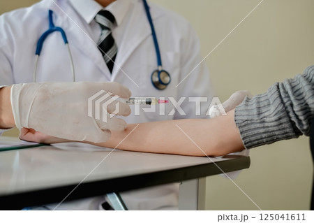 A doctor administers a vaccination to a patient in a clinical setting, highlighting healthcare and wellness. A doctor administers a vaccination to a patient in a clinical setting, highlighting healthcare and wellness. 125041611