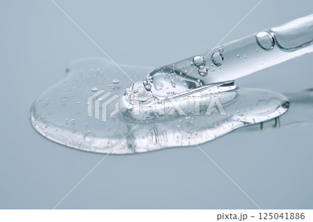 Pipette with serum on a blue background. Product texture. Pipette with serum on a blue background. Product texture. 125041886