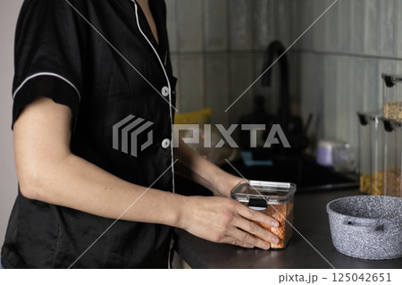 woman holding a container of lentils 125042651