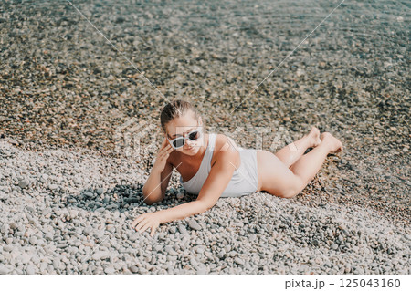 Freelance close up woman hands writing on computer. Well looking middle aged woman typing on laptop keyboard outdoors with beautiful sea view. 125043160