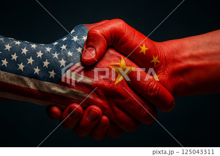 Handshake between US and China symbolizing diplomacy and international agreement, with flags painted on hands against a dark background 125043311