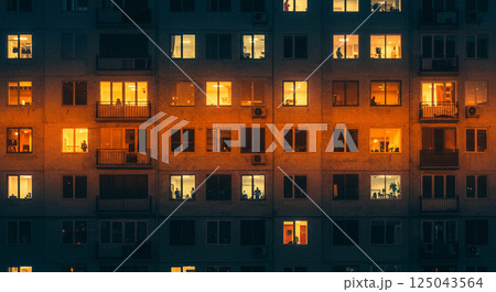 灯るビルの窓越しに垣間見る夜の暮らし 125043564