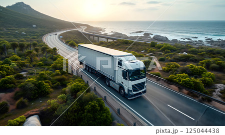 white European semitruck is seen from the sky on a highway backed by vegetation 125044438