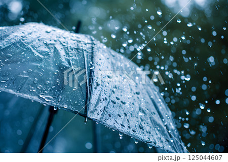Close up, transparent umbrella under rainfall against a background of water droplets splashing. Concept of rainy weather. 125044607