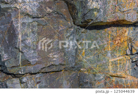 Weathered metamorphic rock texture, colorful stone surface, natural pattern, outdoor, daylight Weathered metamorphic rock texture, colorful stone surface, natural pattern, outdoor, daylight 125044639