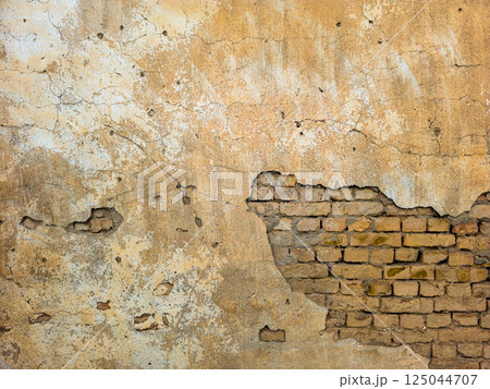 Old brick wall with peeling plaster and exposed bricks Old brick wall with peeling plaster and exposed bricks 125044707