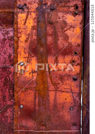 Corroded metal sheets fastened with hex screw heads and welded seams Corroded metal sheets fastened with hex screw heads and welded seams 125044818