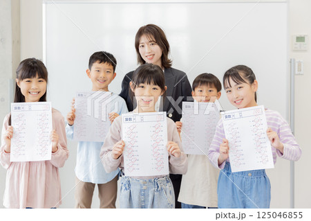 テストで満点を取った小学生と塾の講師 テストで満点を取った小学生と塾の講師 125046855