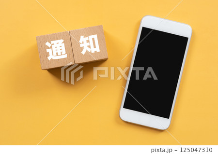 通知と書かれたブロックとスマホ 125047310
