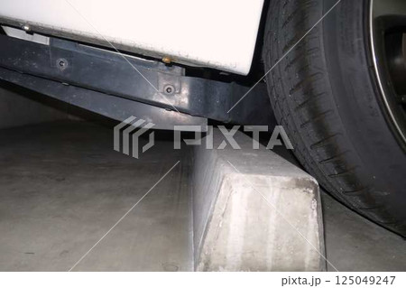 タイヤ止めに当たりそうな自動車のフロア 125049247