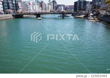 春の福岡、川沿いの桜並木と都市の風景 125052405