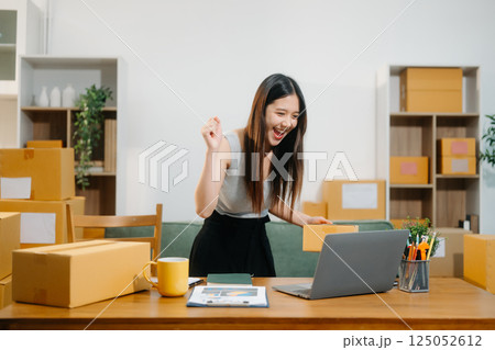 Young business owner woman prepare parcel box and standing check online orders for deliver Young business owner woman prepare parcel box and standing check online orders for deliver 125052612