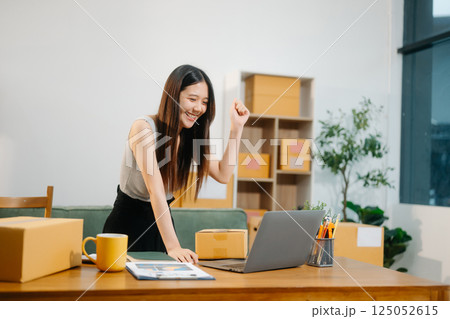 Young business owner woman prepare parcel box and standing check online orders for deliver Young business owner woman prepare parcel box and standing check online orders for deliver 125052615