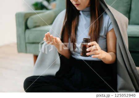 Asian woman sit Depression Dark haired  pensive glance Standing by window and anxiety Copy space with a blanket 125052940