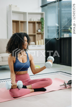 Woman Doing Yoga and Watching Online Tutorials on Laptop, Training in Living Room at home Woman Doing Yoga and Watching Online Tutorials on Laptop, Training in Living Room at home 125053576