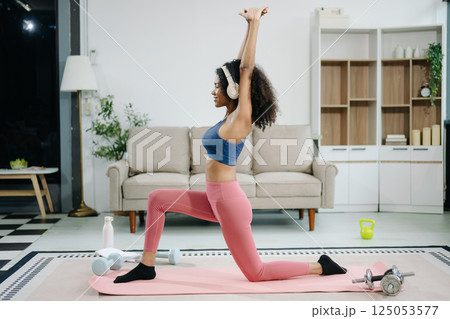 A young woman practices yoga and stretching with a mat and gym props, showcasing wellness, motivation, A young woman practices yoga and stretching with a mat and gym props, showcasing wellness, motivation, 125053577